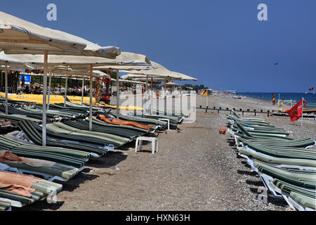 Kemer, Turchia - 29 agosto 2014: spiaggia attrezzata privata sulla costa di Antalya, sedie a sdraio e ombrelloni sulla spiaggia di ghiaia vicino resort di Kemer. Foto Stock