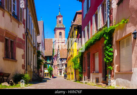 Pittoresca strada con incantevoli case tradizionali in Riquewihr villaggio sulla strada del vino, Francia Foto Stock
