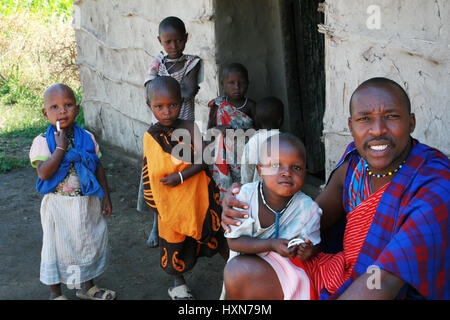 Meserani Snake Park, Arusha, Tanzania - Febbraio 14, 2008: Famiglia africana tribù Masai è sulla soglia di casa sua, suo padre un uomo nero un Foto Stock