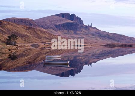 Una rara ancora giorno a Skye significava Loch Fada specchio era ancora permettendo il vecchio uomo di storr per riflettere perfettamente Foto Stock