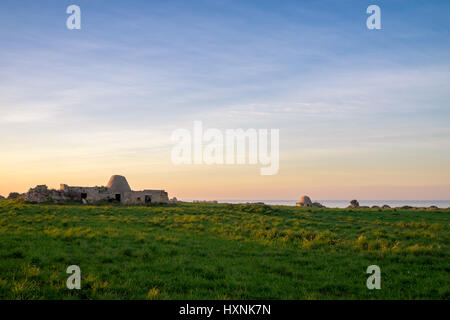 Tramonto sulla costa del trullo case vicino a Polignano a Mare. Regione Puglia, Italia. Foto Stock