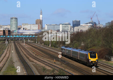 Treno passeggeri voce di servizio al di fuori del centro della città di Birmingham, West Midlands, England, Regno Unito e una vista del centro della città skyline. Foto Stock