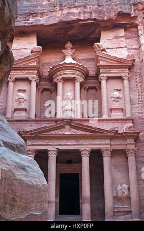 Giordania: la facciata di Al-Khazneh, il Tesoro, uno dei più famosi templi in Petra visti attraverso le rocce di Siq, l'entrata principale canyon Foto Stock