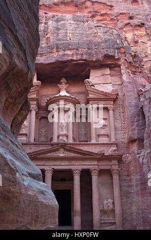 Giordania: la facciata di Al-Khazneh, il Tesoro, uno dei più famosi templi in Petra visti attraverso le rocce di Siq, l'entrata principale canyon Foto Stock