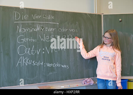 Ragazza facendo grammatica tedesca presso la scuola primaria Foto Stock