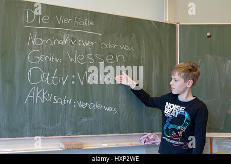 Ragazzo facendo grammatica tedesca presso la scuola primaria Foto Stock