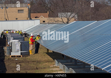 Detroit, Michigan - Lavoratori costruire un 2 megawatt di energia solare per installazione DTE Energy su ex terreni abbandonati. Detroit la popolazione è diminuita da due-thi Foto Stock