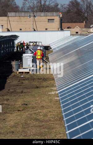 Detroit, Michigan - Lavoratori costruire un 2 megawatt di energia solare per installazione DTE Energy su ex terreni abbandonati. Detroit la popolazione è diminuita da due-thi Foto Stock