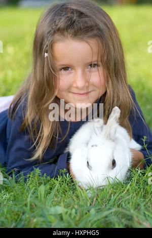 Bambina di cinque anni tiene un coniglio (Mr), fünfjähriges Mädchen hält ein Kaninchen (MR) Foto Stock