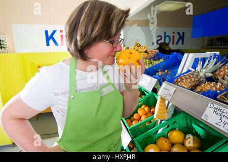 Il commercio al dettaglio shop assistant profumi di frutta (MR), Einzelhandelsverkäuferin riecht un Frucht (MR) Foto Stock