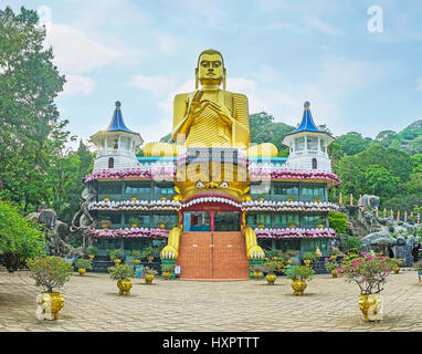 DAMBULLA, SRI LANKA - 27 novembre 2016: la facciata del tempio d'oro con la gigantesca statua dorata di Buddha nel Dhamma Chakka pongono (laminazione wh Foto Stock