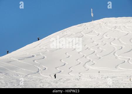 Gli sciatori e scolpito le tracce lasciate in fresco fuori pista, neve Hauteluce / Les Contamines ski area, Savoie, Francia, febbraio. Foto Stock