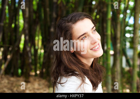 Close up ritratto di attraente giovane donna sorridente davanti di alberi di bambù Foto Stock