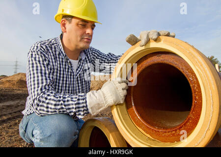 Costruzione di opere del lavoratore con il tubo, Bauarbeiter arbeitet mit Rohr Foto Stock