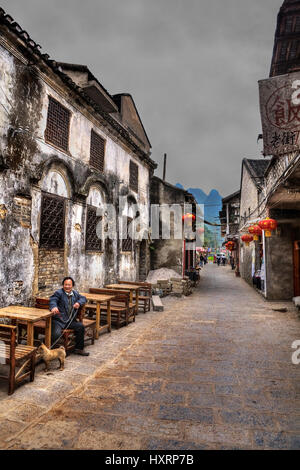 Xinping Village, Yangshuo, Guangxi, Cina - 29 Marzo 2010: la città antica, attrazione turistica, nella strada stretta con le lanterne cinesi per la caffetteria all'aperto Foto Stock