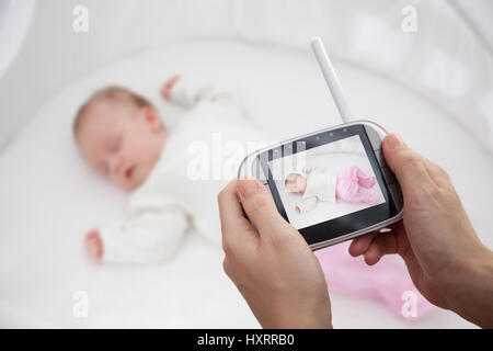 Mano azienda video baby monitor per la sicurezza del bambino Foto Stock