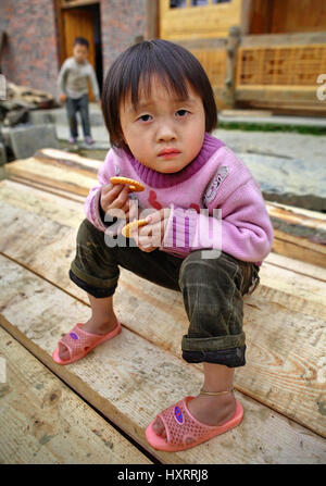 Villaggio Zengchong, Guizhou, Cina - 11 Aprile 2010: Ragazza di quattro anni, a giocare all'aperto nella campagna in minoranza in Cina, 11 aprile 2010. Asi Foto Stock