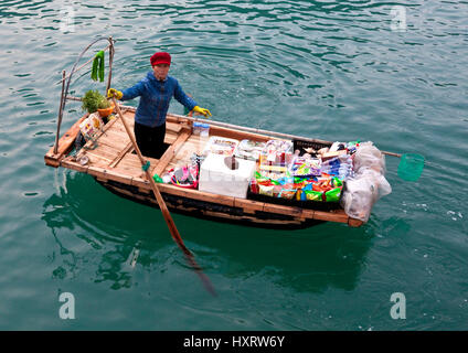 Donna vietnamita offre prodotti per la vendita sulla Baia di Ha Long Foto Stock