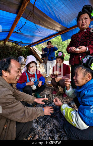 Villaggio Langde, Guizhou, Cina - 16 Aprile 2010: Langde Shang Miao villaggio nella contea di Rongjiang, uomo cinese agricoltore seduto in un fuoco estinto con orn Foto Stock