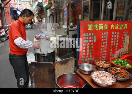 Shanghai, Cina - 20 Aprile 2010: Outdoor eatery in aperto, lo chef prepara il cibo sulla strada. Foto Stock
