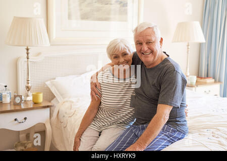 Contenuto coppia senior seduta sul letto al mattino Foto Stock