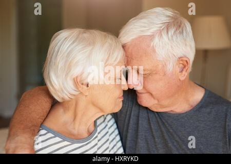 Affettuosa coppia senior seduti insieme a casa Foto Stock
