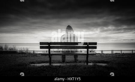 I fantasmi di figura seduta su una panchina nel parco Foto Stock