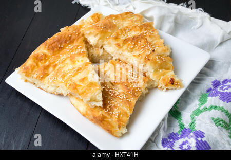 Torta di formaggio ricoperto con sesamo su una piastra Foto Stock