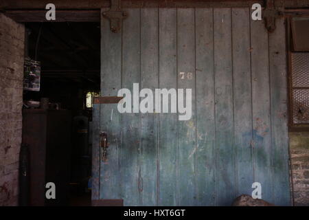 Chiudere ups di una vecchia stalla che conduce a un workshop Foto Stock