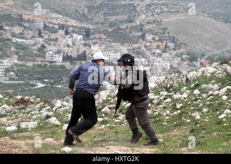 Madama, West Bank. 30 Mar, 2017. Una dimostrazione per commemorare il giorno di terra in Cisgiordania villaggio di Madama, nel sud di Nablus, è diventata violenta come i dimostranti palestinesi si sono scontrati con le forze di sicurezza israeliane. Soldati israeliani sparato gas lacrimogeni e pallottole di gomma a dimostranti palestinesi, che a loro volta sono state gettando le rocce in loro. La protesta si è infiltrata da mascherare i coloni israeliani. Secondo la Mezzaluna Rossa Palestinese 45 palestinesi sono stati feriti sulla scena, mentre senza lesioni dei soldati israeliani sono stati segnalati. Credito: ZUMA Press, Inc./Alamy Live News Foto Stock