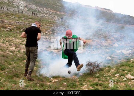 Madama, West Bank. 30 Mar, 2017. Una dimostrazione per commemorare il giorno di terra in Cisgiordania villaggio di Madama, nel sud di Nablus, è diventata violenta come i dimostranti palestinesi si sono scontrati con le forze di sicurezza israeliane. Soldati israeliani sparato gas lacrimogeni e pallottole di gomma a dimostranti palestinesi, che a loro volta sono state gettando le rocce in loro. Credito: Mohammed Turabi/ImagesLive/ZUMA filo/Alamy Live News Foto Stock