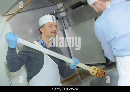 Macellaio di insegnamento di una giovane come vendere la carne Foto Stock