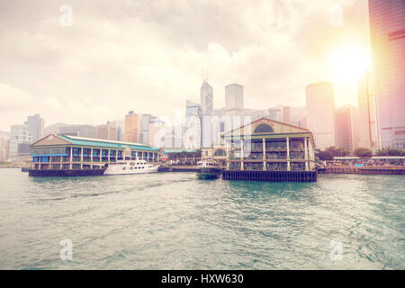 Nel tardo pomeriggio tramonto sul Traghetto Central Pier sull isola di Hong Kong con il quartiere finanziario del centro cittadino in background. Con la sua Edwardian architectu Foto Stock