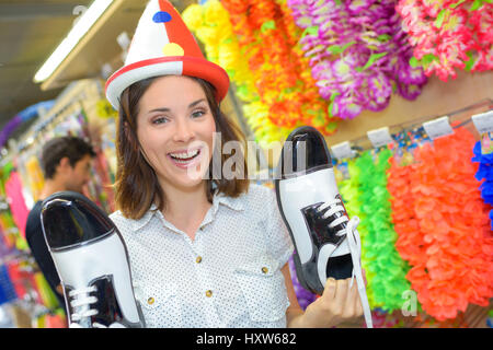 Donna che indossa il clown del cappello e scarpe di contenimento Foto Stock