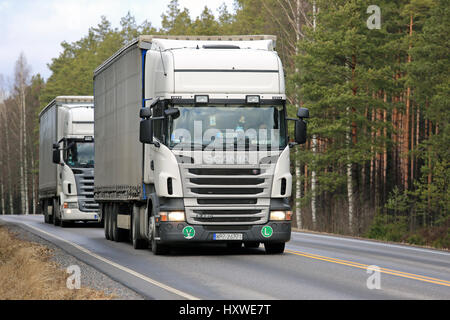 SALO, Finlandia - 17 Marzo 2017: due bianchi Scania R420 curtainsider semi rimorchio camion provenienti dalla Polonia si muovono lungo la strada rurale nel sud della Finlandia. Foto Stock