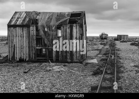 Rifugi abbandonati, barca da pesca e pista, Dungeness, Kent, Inghilterra, UK versione in bianco e nero Foto Stock