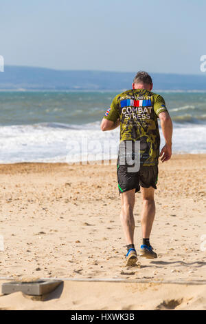 Uomo di prendere parte nella tempesta di sabbia sfida a sostegno di combattere lo stress dei veterani della salute mentale della carità a Bournemouth in Marzo Foto Stock