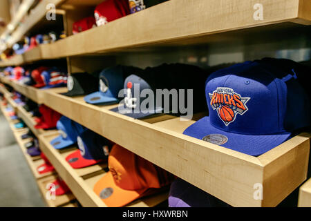 Una vasta gamma di berretti da baseball con NBA loghi squadra riempiono gli scaffali del NBA store in Manhattan. Foto Stock