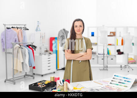 I giovani designer di moda sorridente e in piedi davanti al banco in officina Foto Stock