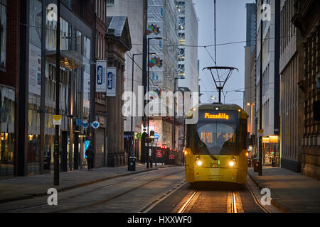 Un giallo tram Metrolink sulla parte inferiore Mosley Street Manchester City Centre, England Regno Unito. Foto Stock