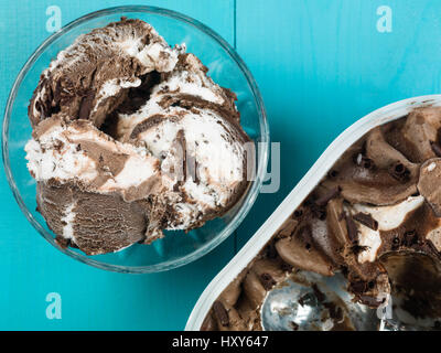 Cioccolato e gelato alla vaniglia in una ciotola contro uno sfondo blu Foto Stock