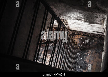 Vecchio vuoto bunker abbandonati interno con arrugginita scala di metallo che scendono dalla camera oscura alla luce Foto Stock