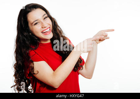 Funny giovane donna dispositivo di puntamento con entrambe le mani a vuoto. Isolato su bianco Foto Stock