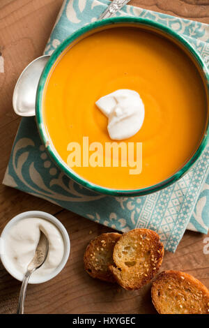 Zuppa di zucca in una ciotola con crema di noce di cocco e fritti crostini di pane con sesamo Foto Stock