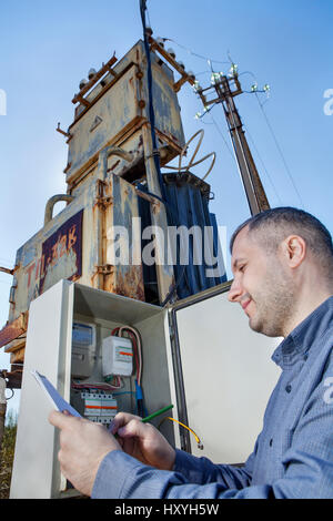 Abitante tecnico di scrittura e di lettura del misuratore di energia elettrica negli appunti. Foto Stock