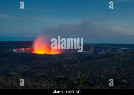 Un lago di lava attivo all'interno del cratere Halemaumau sull Kilauea illumina vapore vulcanico salendo nella parte anteriore del cielo notturno sulla Big Island, Hawaii, Stati Uniti d'America. Foto Stock