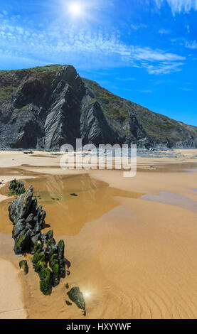 Le formazioni rocciose sulla spiaggia sabbiosa e sunshiny cielo blu con nuvole cumulus (Algarve, Costa Vicentina, Portogallo). Foto Stock