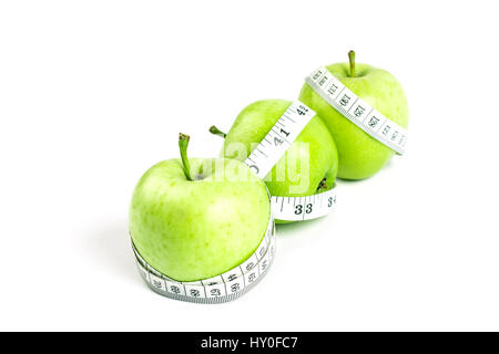 La mela verde con nastro di misurazione su sfondo bianco nel concetto di sano e dieta Foto Stock