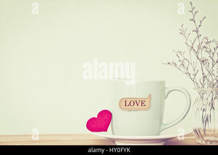 Tazza di caffè la tazza con il cuore rosso shapeand amore tag word sul tavolo di legno , Romanticismo e amore il giorno di San Valentino il concetto di sfondo Foto Stock