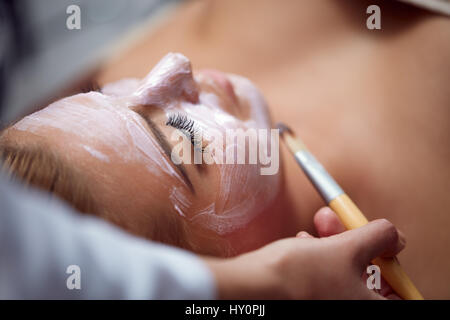 Bella giovane donna avente un trattamento del viso trattamento cosmetico. Foto Stock